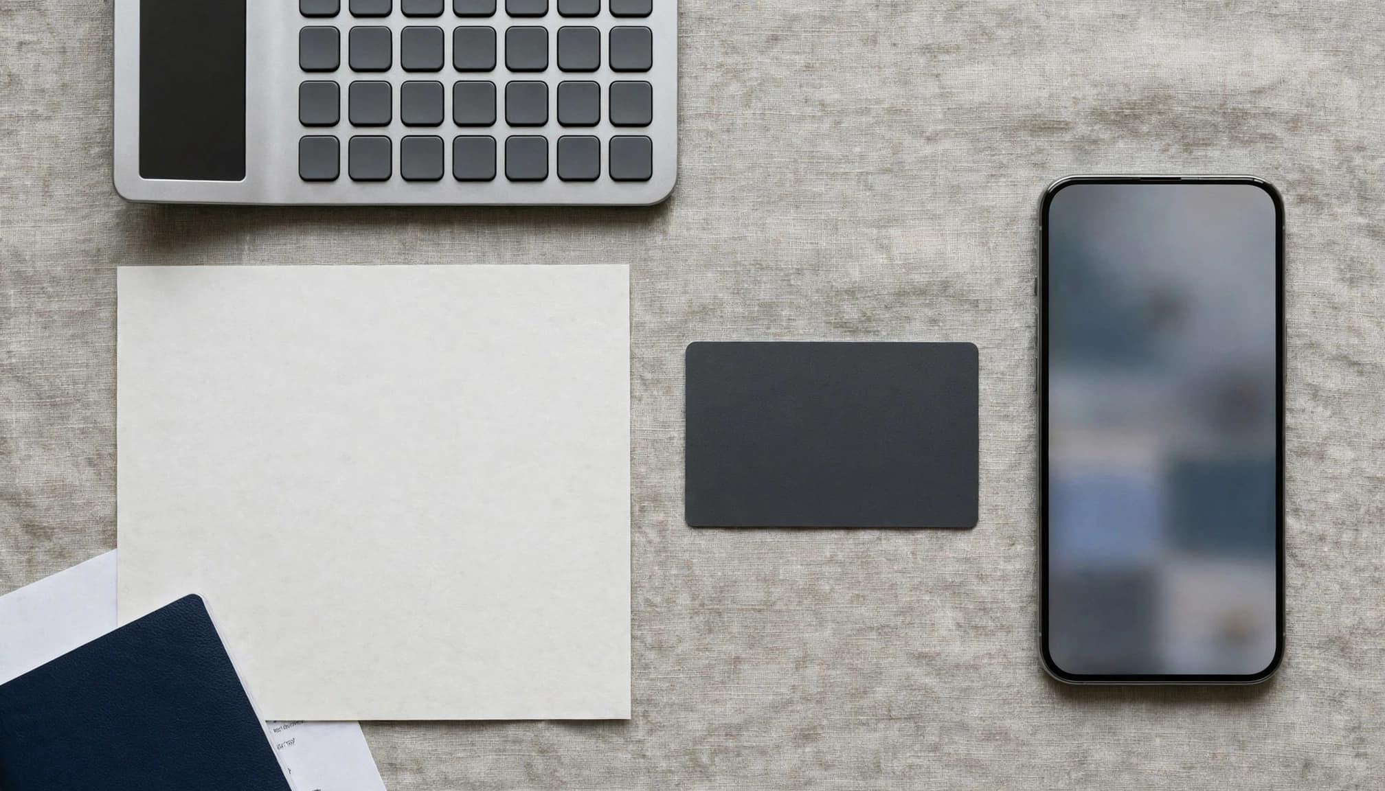 Calculator, terms sheet, ID document, bank card, and blurred phone screen on a desk.